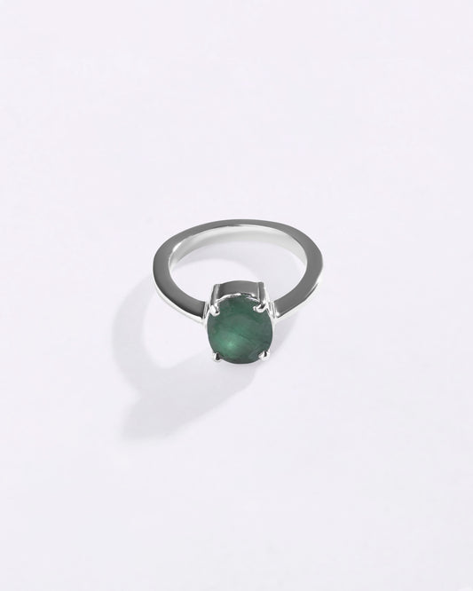 Silver ring with a green emerald on a white background